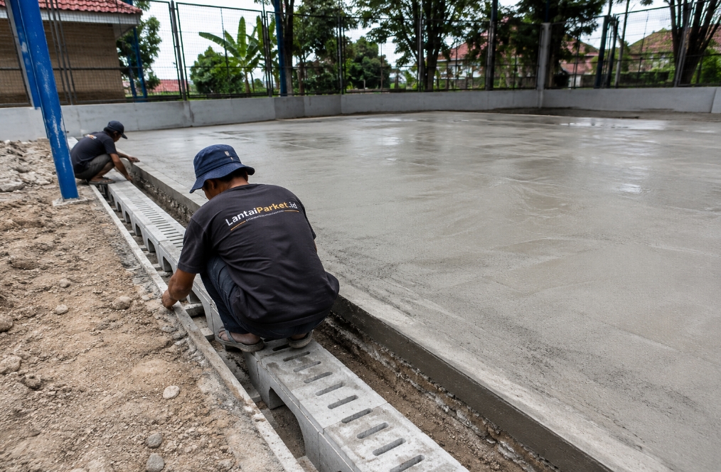 Lantai Lapangan Basket Outdoor Surabaya: Material Tahan Cuaca Tropis 2026 3 sistem drainase lapangan basket outdoor kemiringan