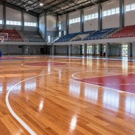 Jasa Pasang Lantai Kayu Multifungsi Gym & Basket 2026 8 Lantai lapangan basket kayu di GOR dengan tribun penonton