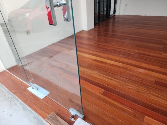 Portofolio Proyek Lantai Parket & Lantai Kayu 23 Sambungan lantai parket di bawah pintu kaca frameless kantor Nganjuk