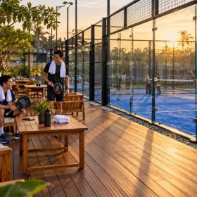 Lantai Kayu Lapangan Padel: Aturan FIP, Area yang Tepat, dan Harga 2026 11 Lounge decking kayu di sisi lapangan padel outdoor saat sore